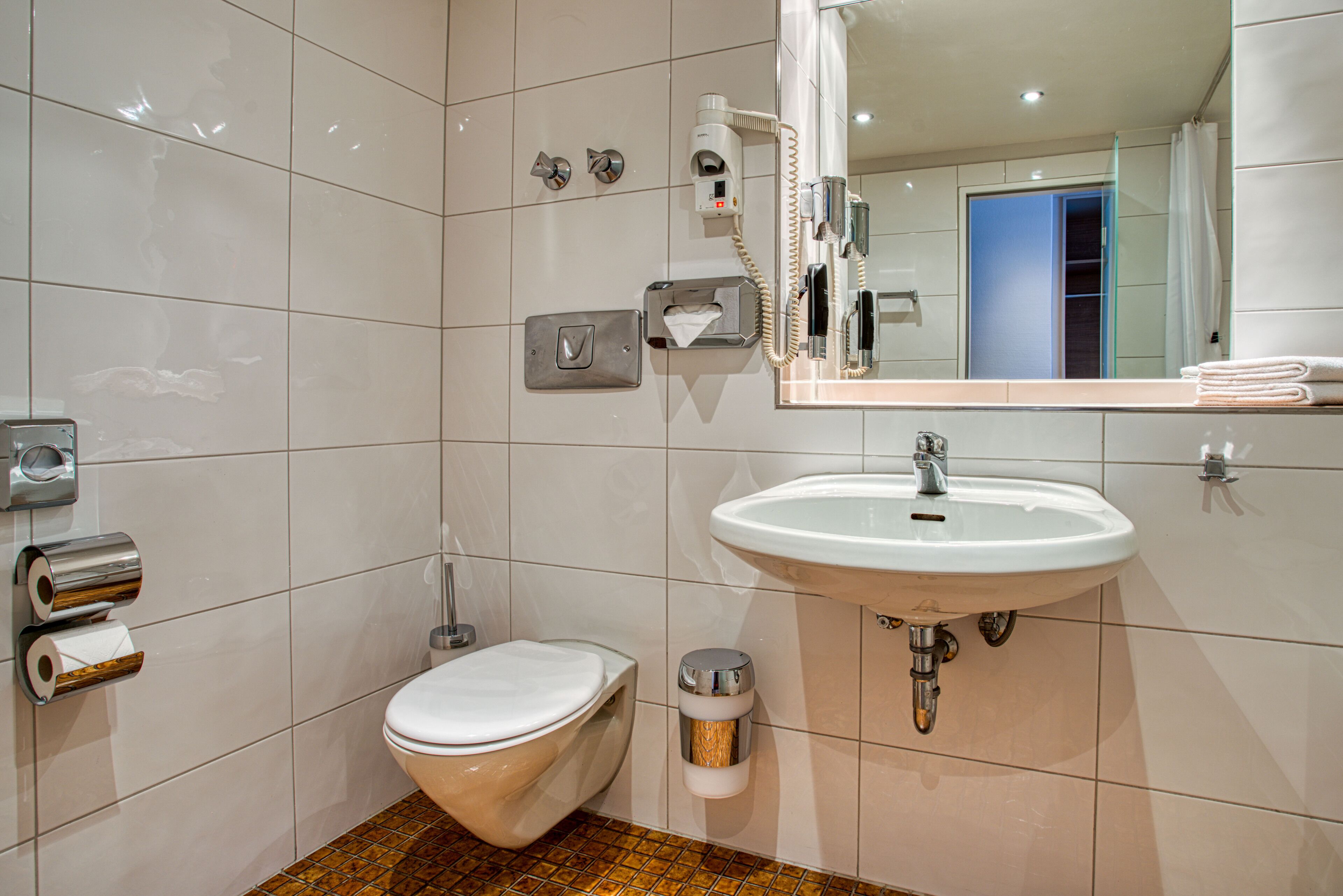 A modern bathroom with a toilet, bidet, and sink.