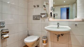 A modern bathroom with a toilet, bidet, and sink.