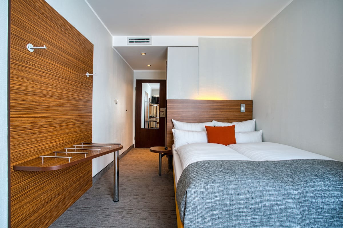 Ropa de cama de alta calidad y caja de seguridad en la habitación