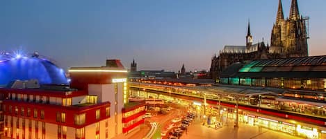 Ein Bahnhof mit mehreren Gleisen und einer großen Kathedrale im Hintergrund.