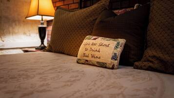 Un letto con un cartello che riporta la scritta 'Life's too short to drink bad wine' e una lampada sullo sfondo.