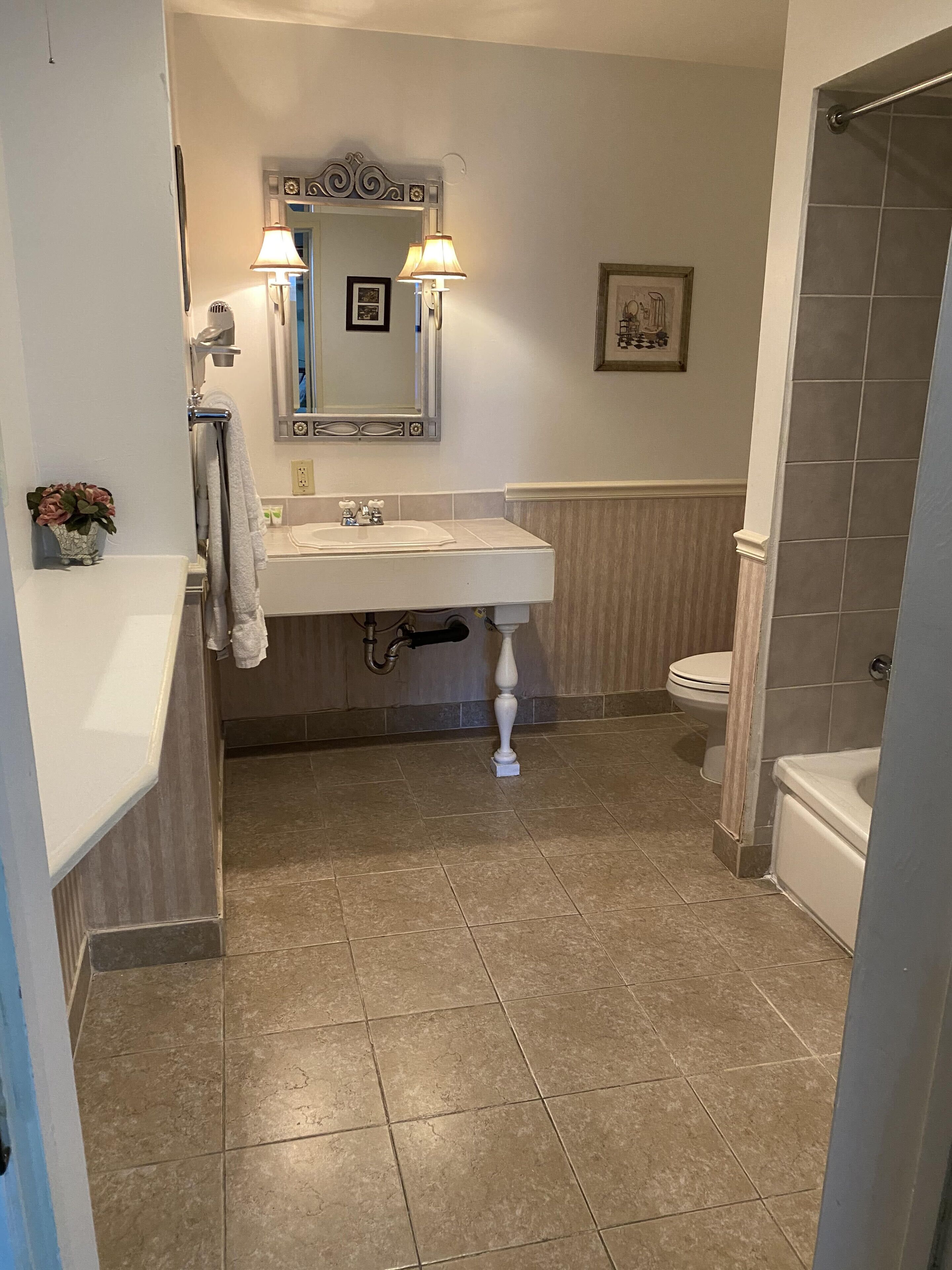 Un baño con lavabo, espejo e inodoro.