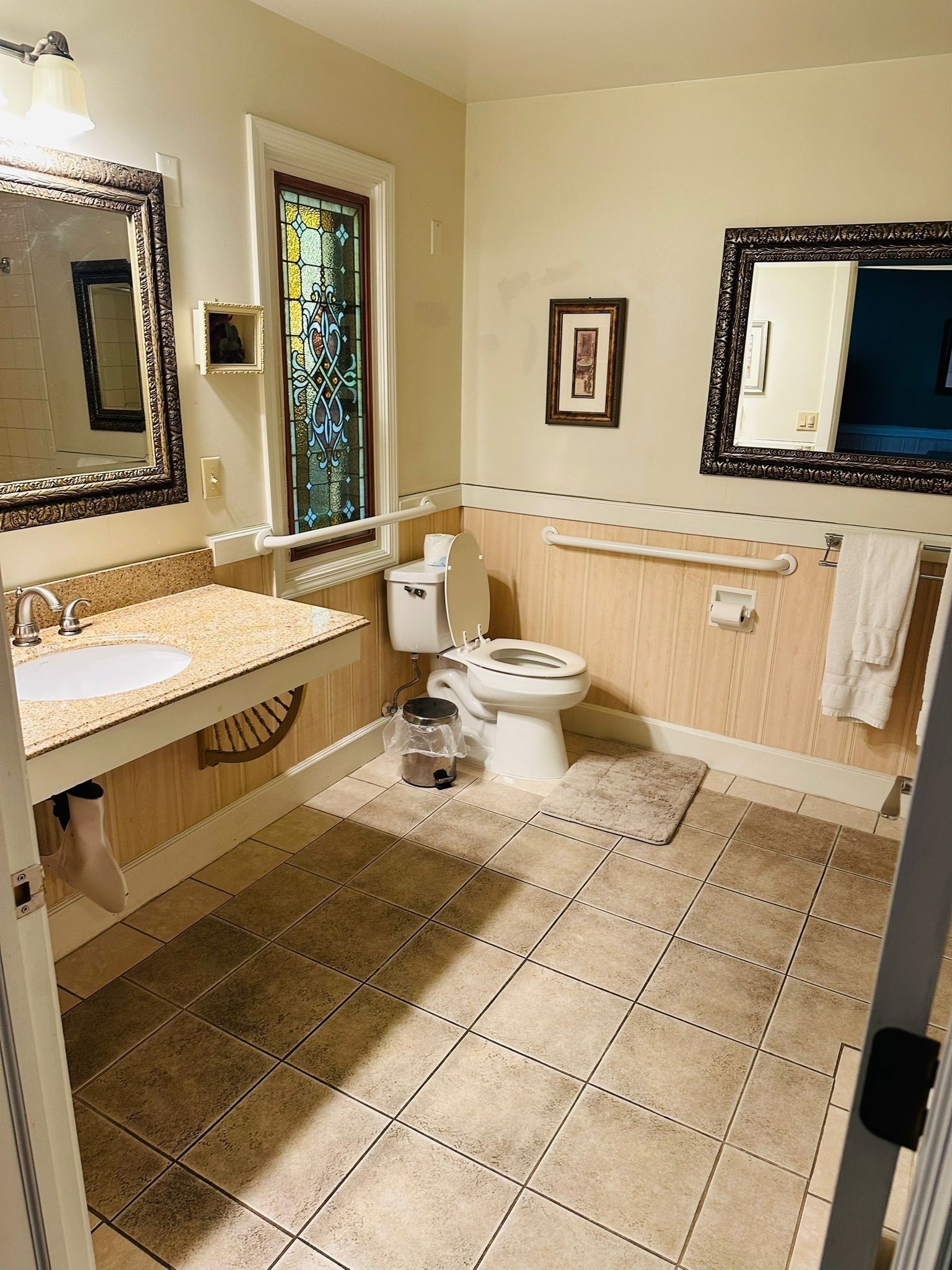 A bathroom with a sink, toilet, and vanity mirror.