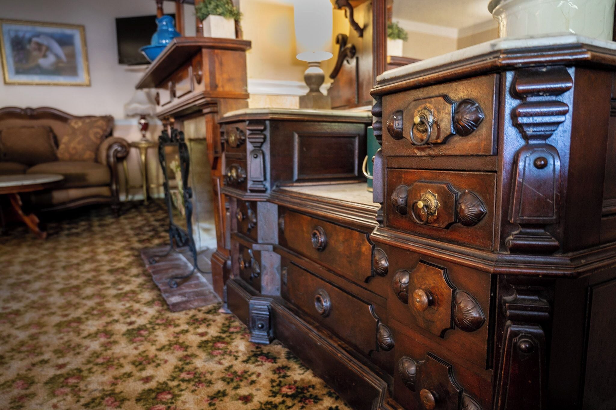 Una habitación con muebles de madera antiguos, incluyendo un aparador y un sofá.