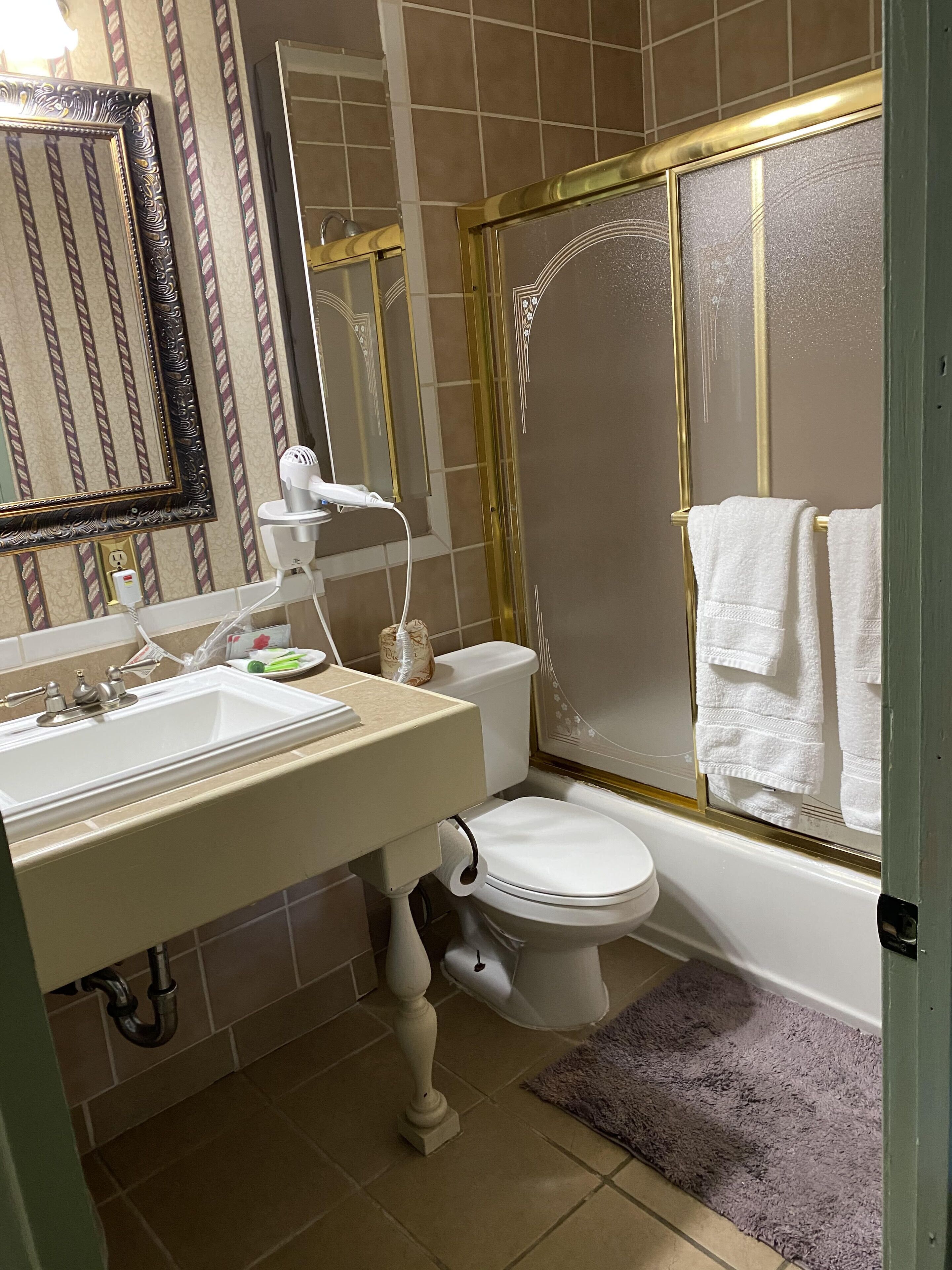 Een badkamer met wastafel, toilet en douche.