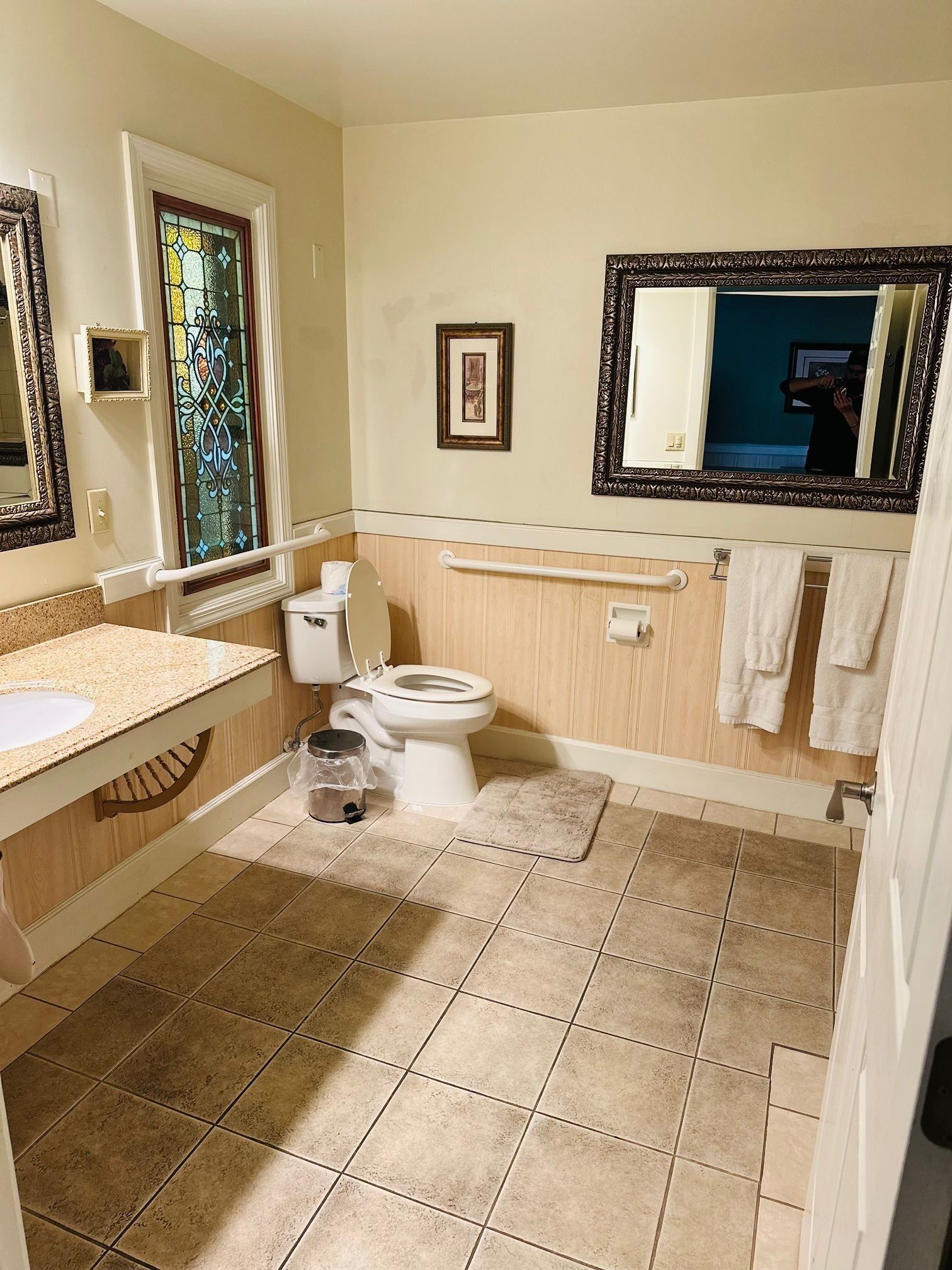 Une salle de bain comprenant des toilettes, un lavabo, un meuble-lavabo et un grand miroir.