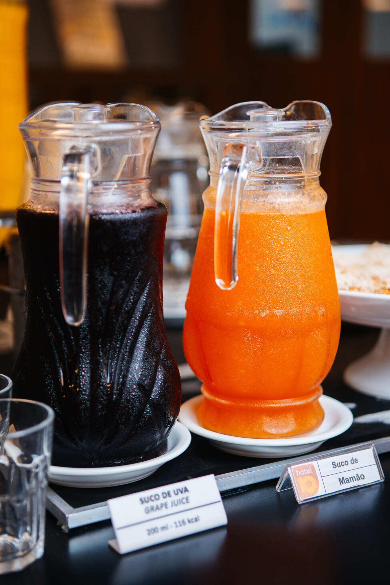 Two pitchers of beverages, one dark and one orange, with labels indicating they are grape juice.