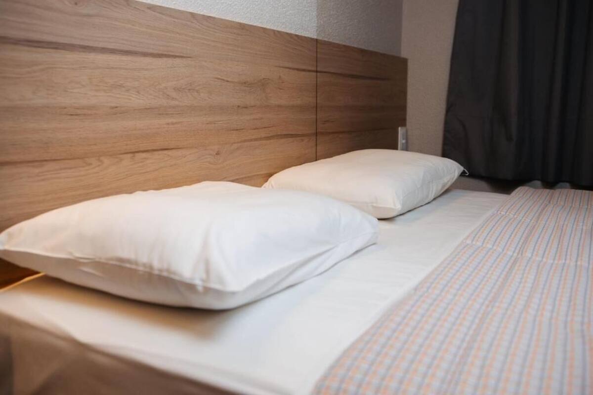 A bed with white bedding and a wooden headboard.