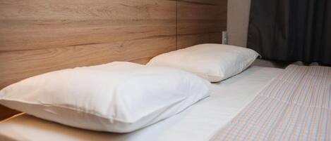 A bed with white bedding and a wooden headboard.