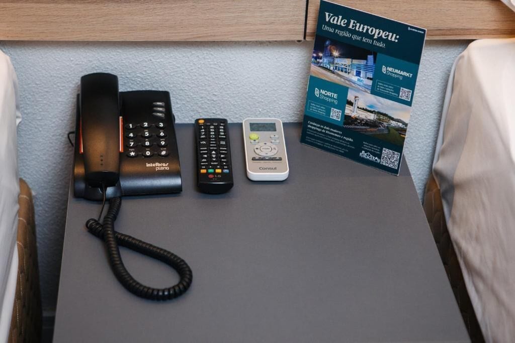 A desk with a landline phone, a cordless phone, a mobile phone, and a brochure.