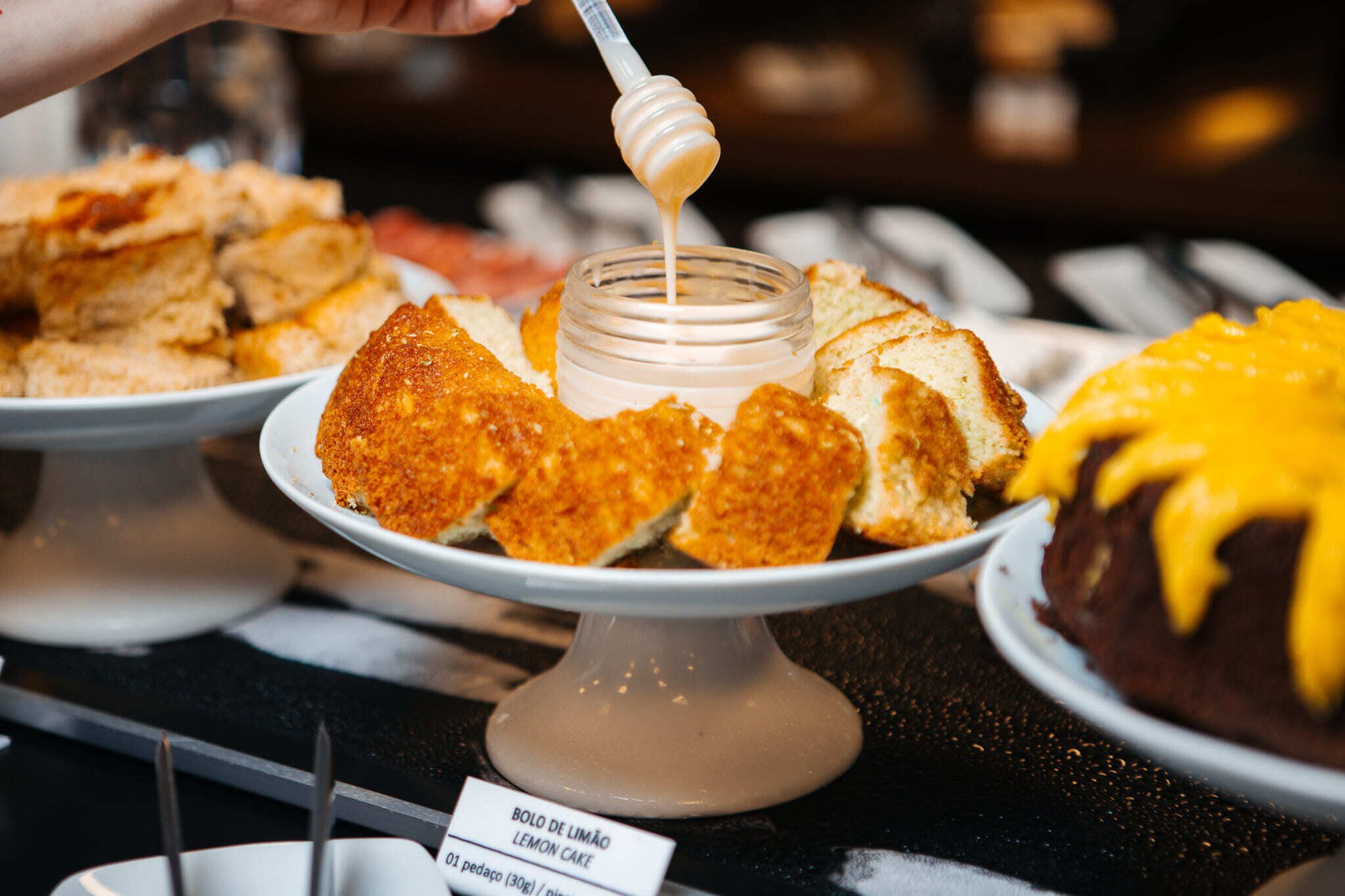 A dessert display with a lemon cake and various other pastries.