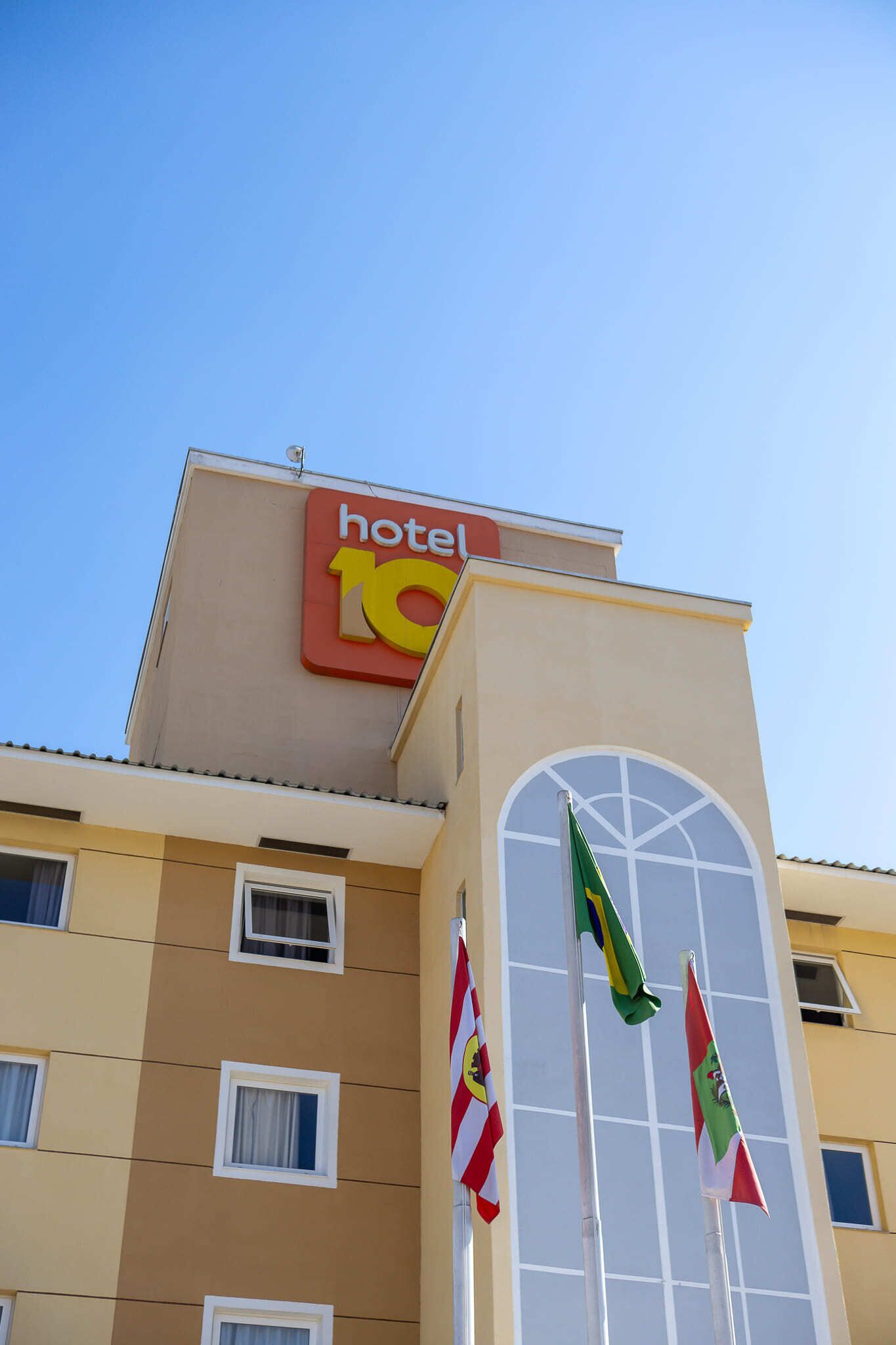 Un edificio de hotel con un cartel que indica que es un hotel de 10 estrellas. Se observan varias ventanas en la fachada y dos banderas.