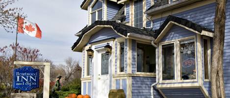 A two-story building with a blue exterior and a sign for Heartwood Inn and Spa.