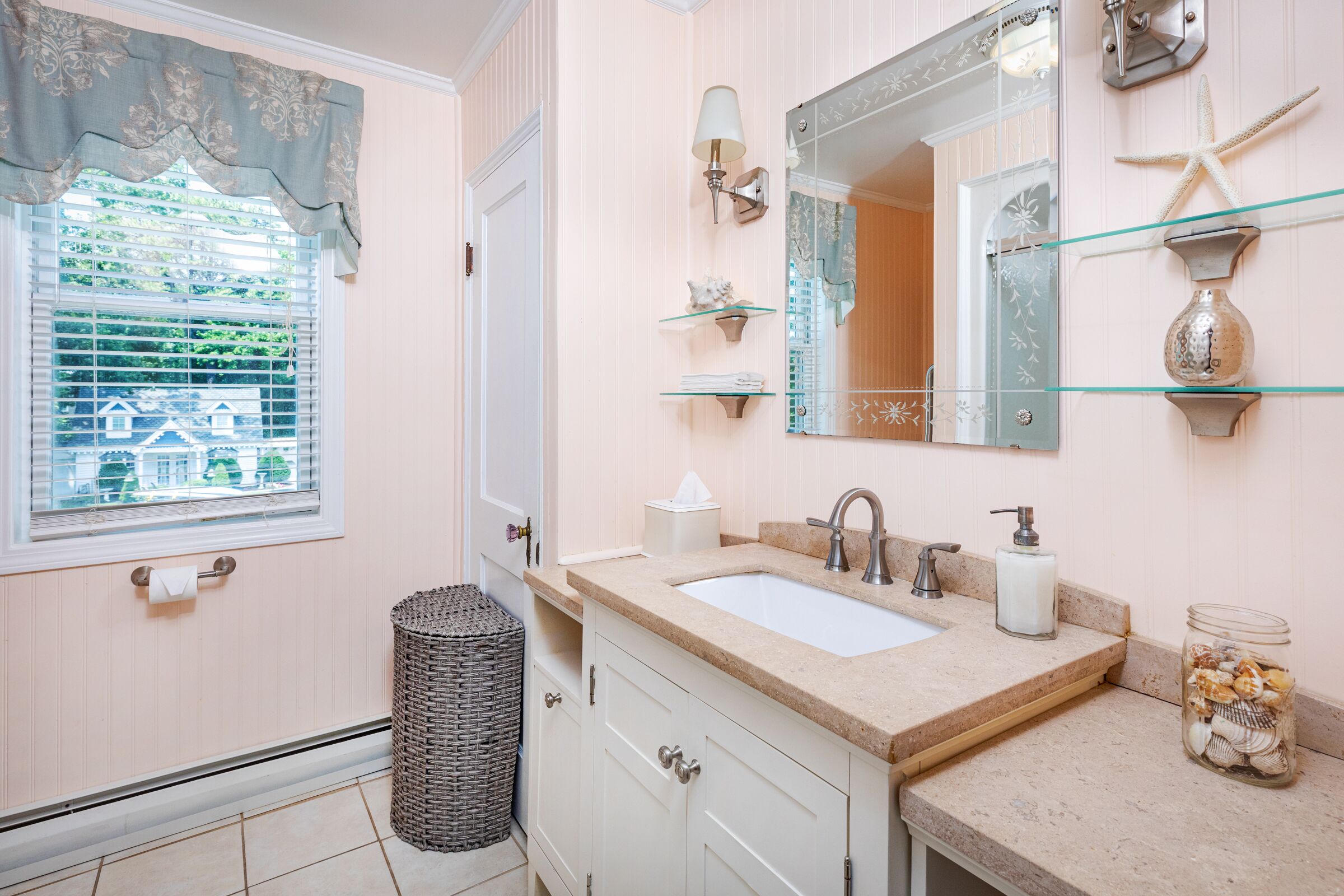 Une salle de bain équipée d’un lavabo, d’un miroir et d’objets décoratifs.