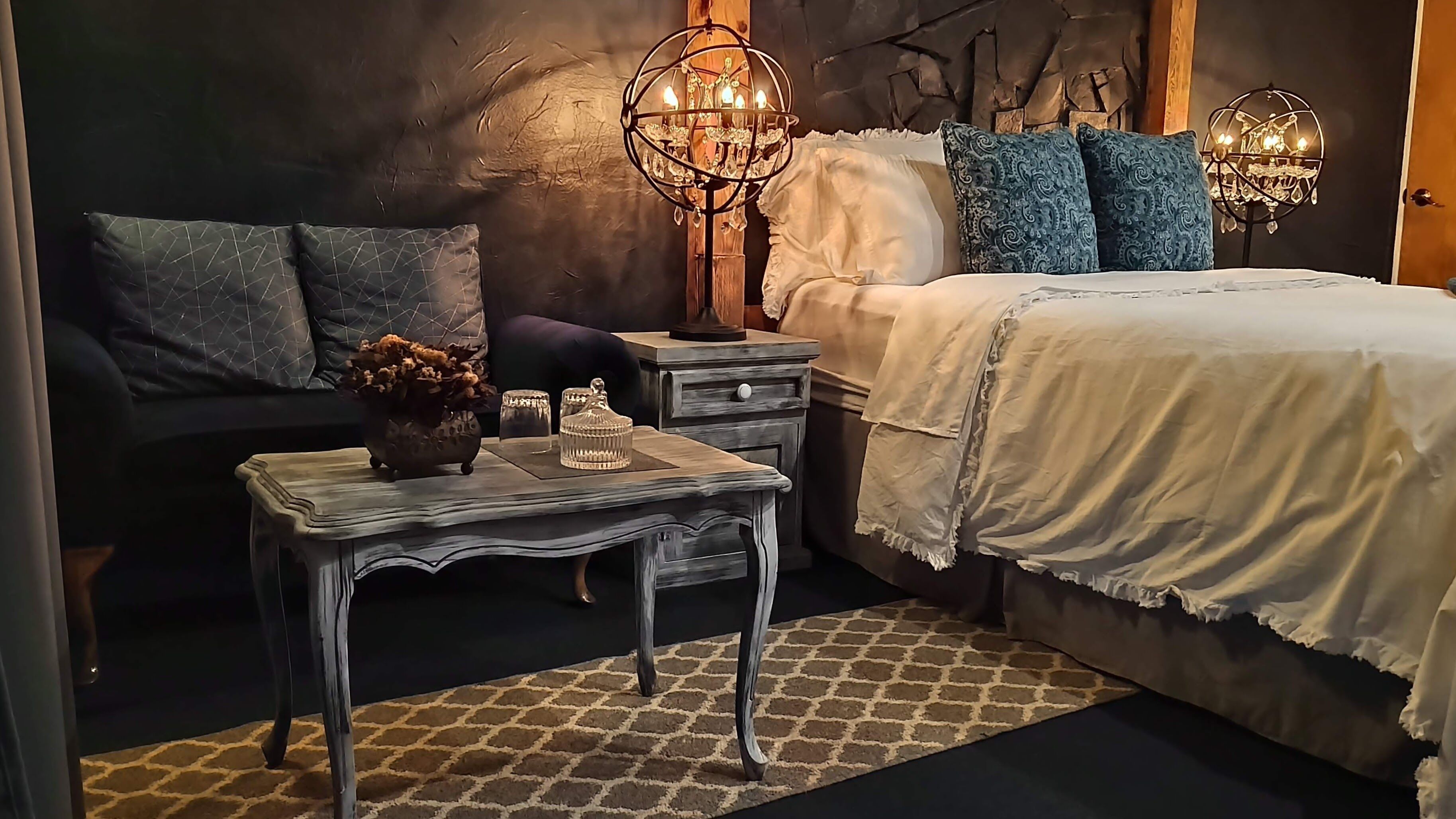 Un dormitorio con cama, mesitas de noche y un candelabro.