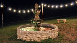 A stone fountain with water spouting from the top, surrounded by a stone border. - Nativa Posada & Spa (Montemorelos)