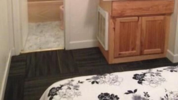 Un baño con tocador de madera, espejo y zona de ducha.