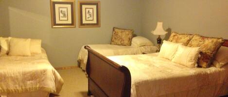 A bedroom with two single beds, a wooden headboard, a nightstand, and a lamp.