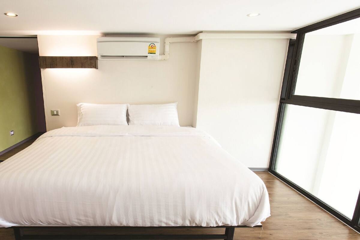 Una camera da letto con un letto grande, una finestra e un condizionatore d'aria.
