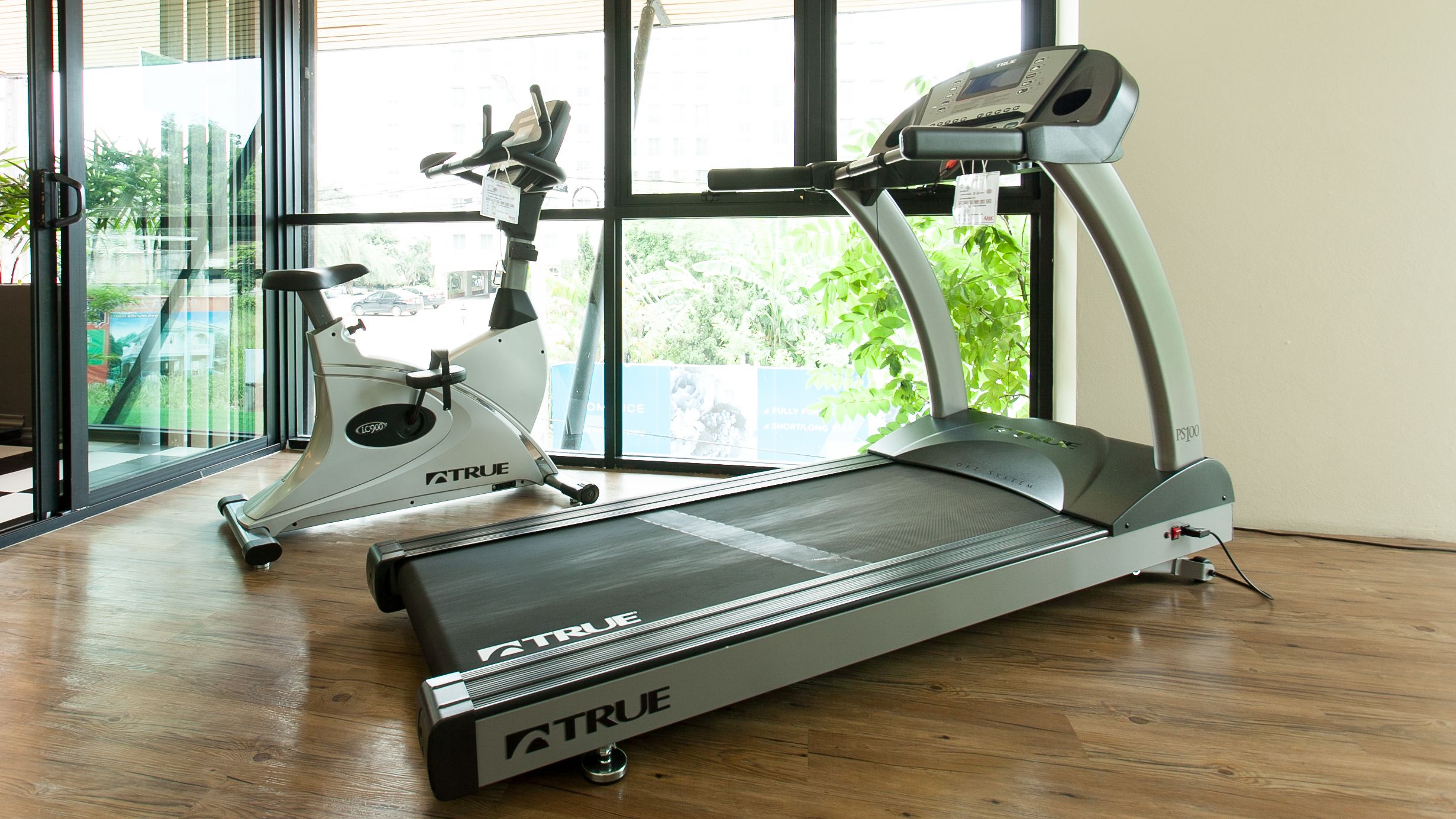 A gym with a treadmill, an elliptical, and a stationary bike.