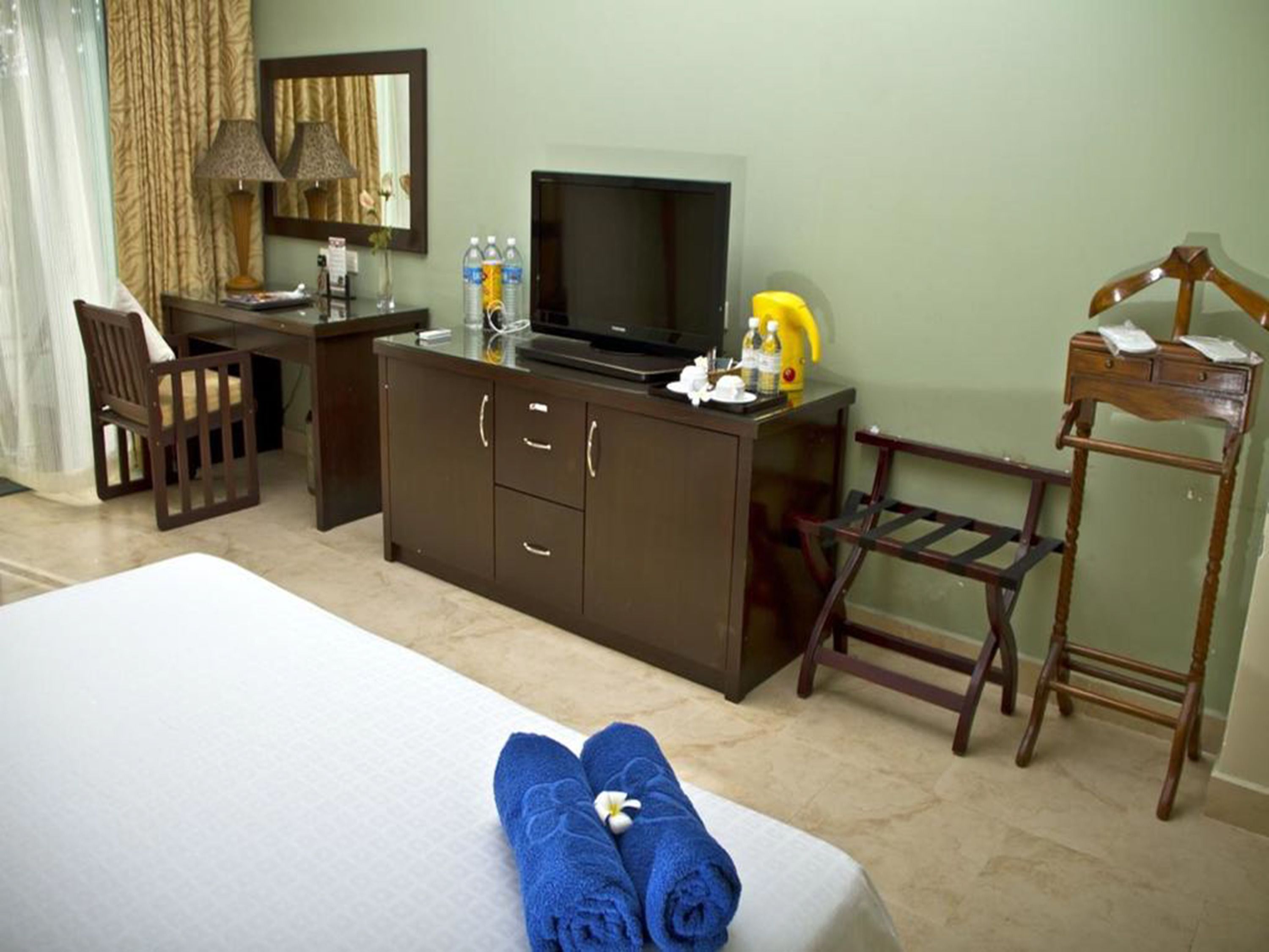 A hotel room with a bed, a desk, a television, and a chair.