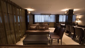 Una sala moderna con sofá de cuero, mesa de comedor y sillas.