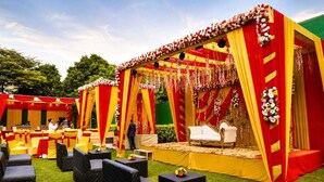 An outdoor event space with a stage, seating, and floral decorations. - Hotel Maiden Residency (Ghaziabad)