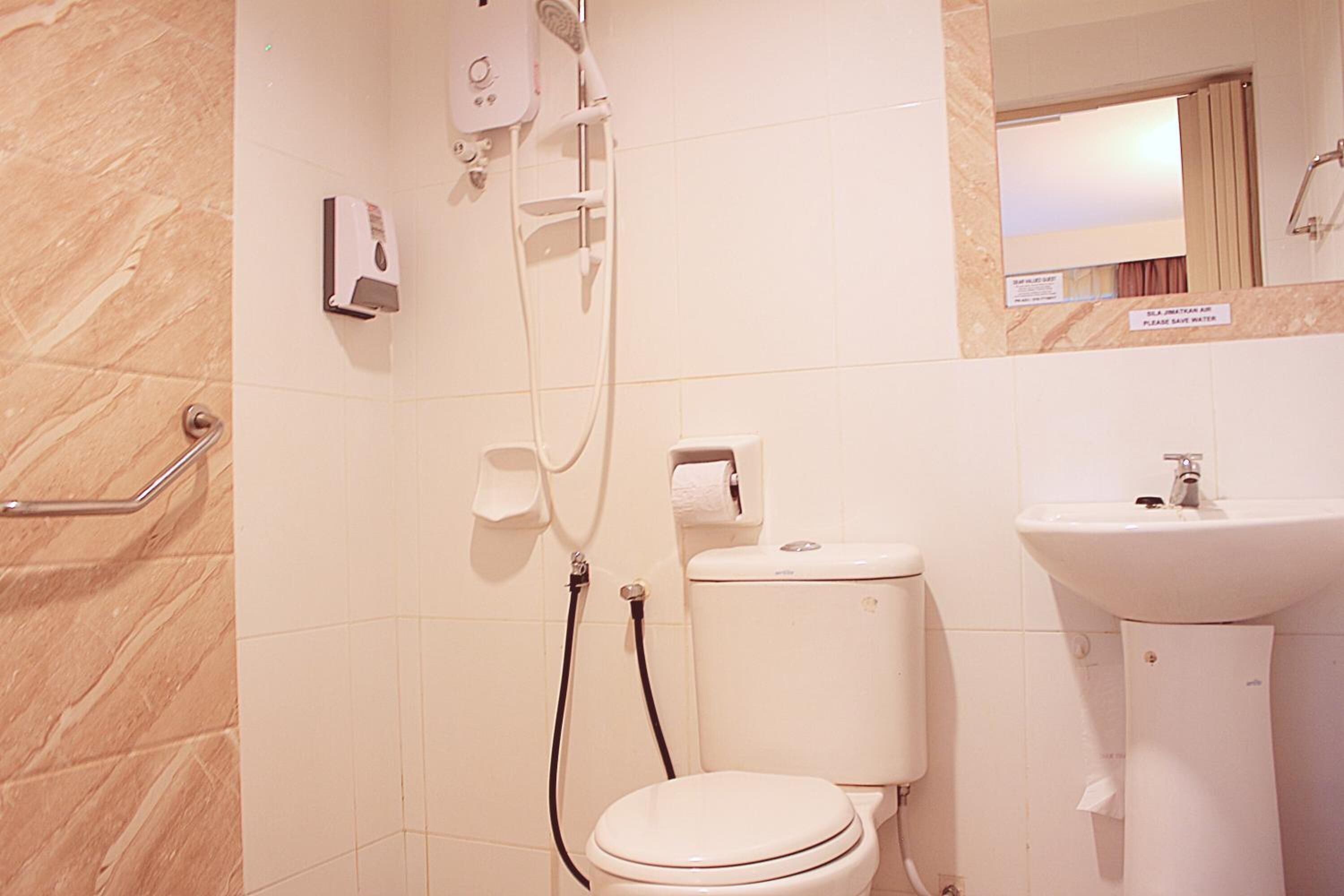 Une salle de bain avec des toilettes, un lavabo et une douche.