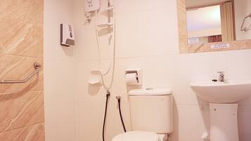 Une salle de bain avec des toilettes, un lavabo et une douche.
