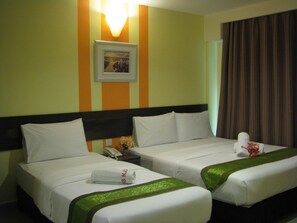 A hotel room with two beds, a nightstand, a telephone, and a framed picture on the wall. - Sun Inns Rest House Kuantan (Kuantan)