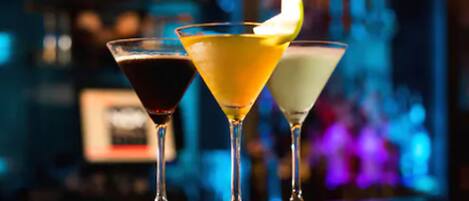 Three cocktails on a bar counter with a blurred background.