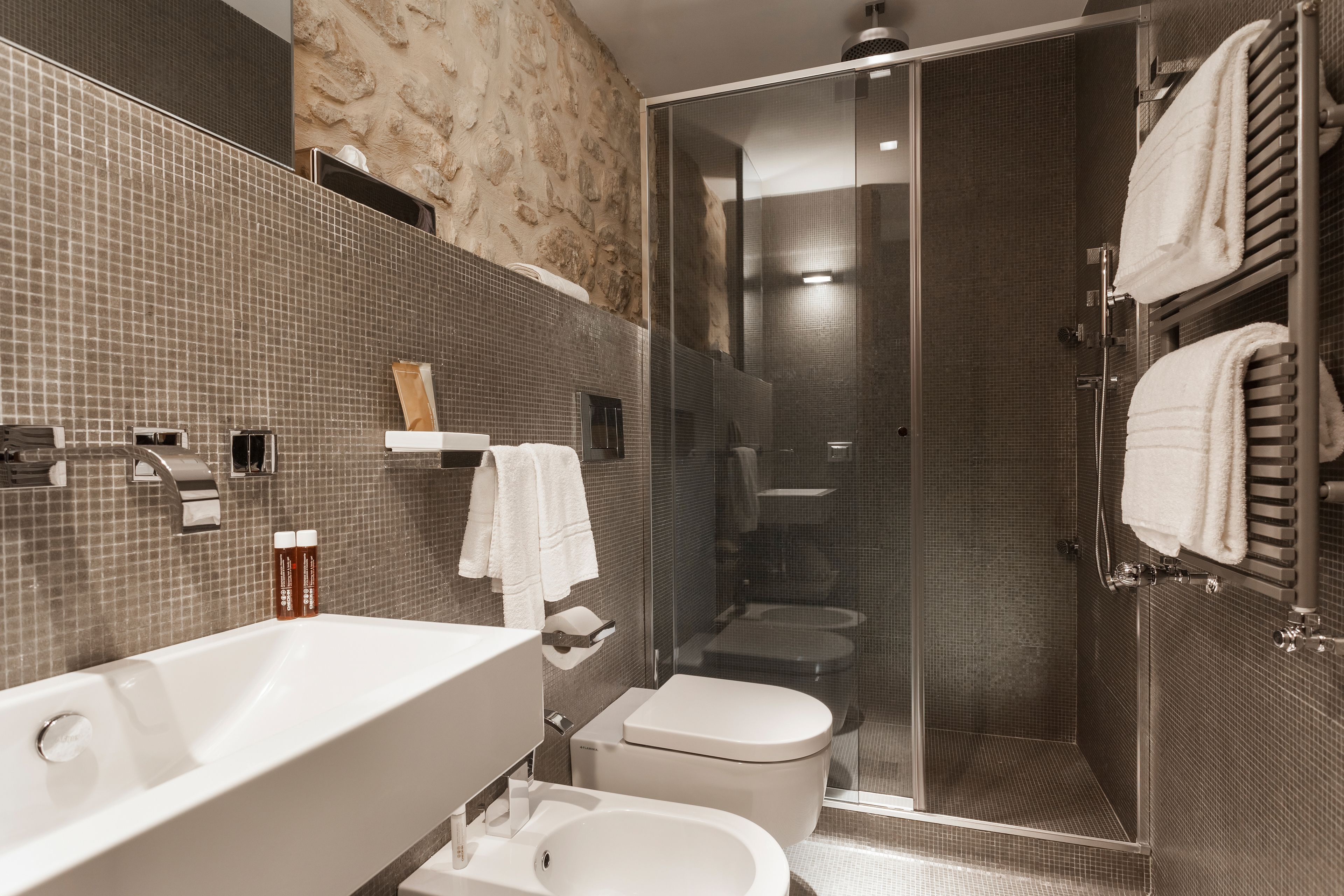 Un baño moderno con un lavamanos grande, inodoro y zona de ducha.