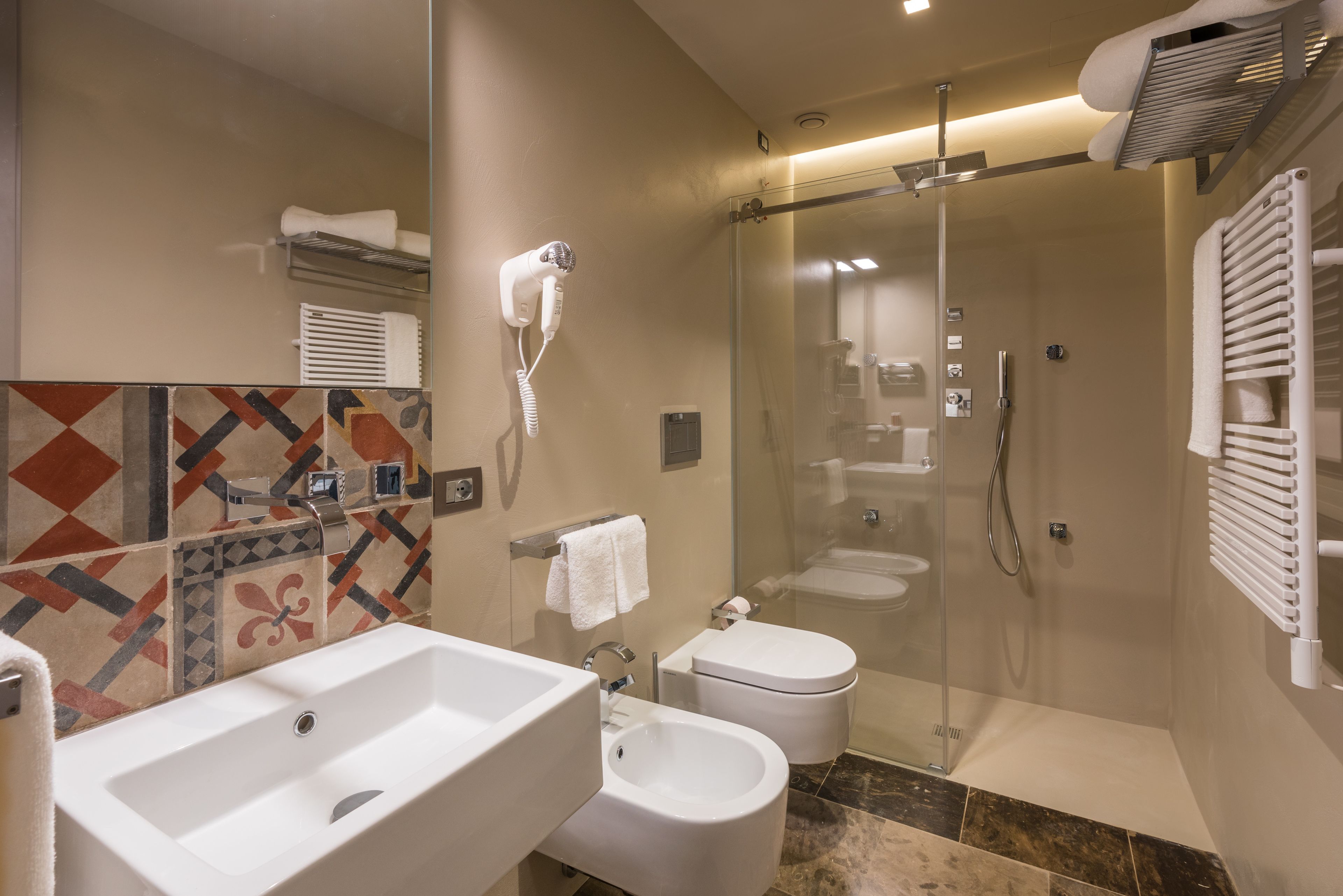 Un baño moderno con un lavamanos grande, inodoro y zona de ducha.