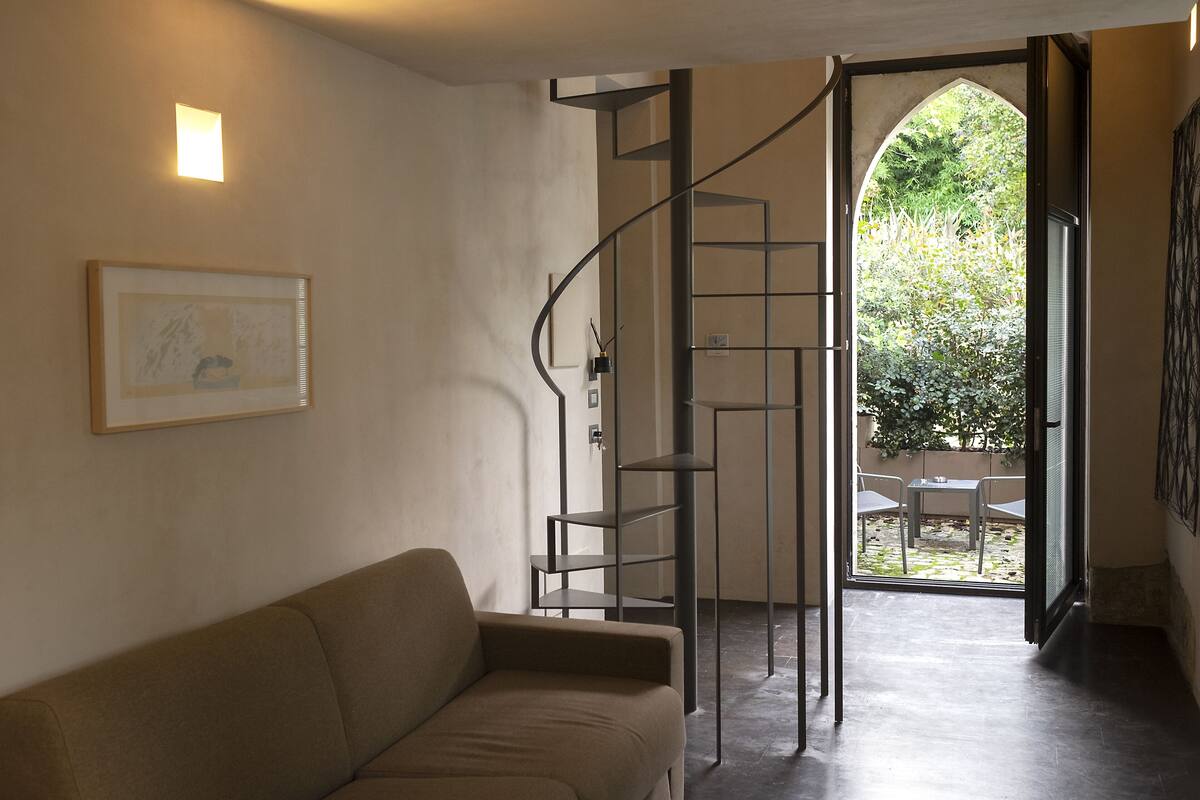 Un intérieur moderne avec un escalier en colimaçon menant à un espace extérieur.