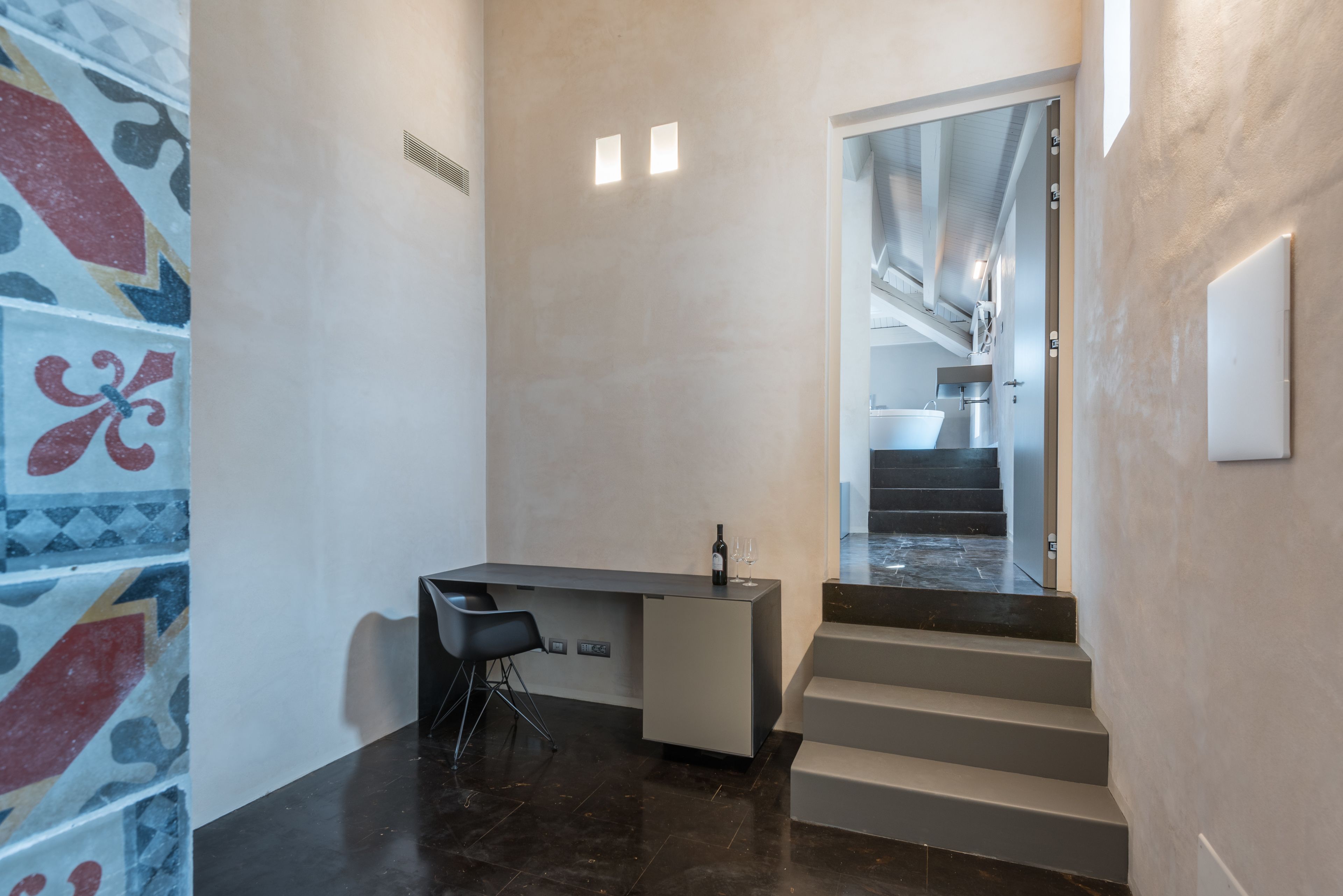 Un interior moderno con un escritorio, una silla y una escalera que lleva a un baño.