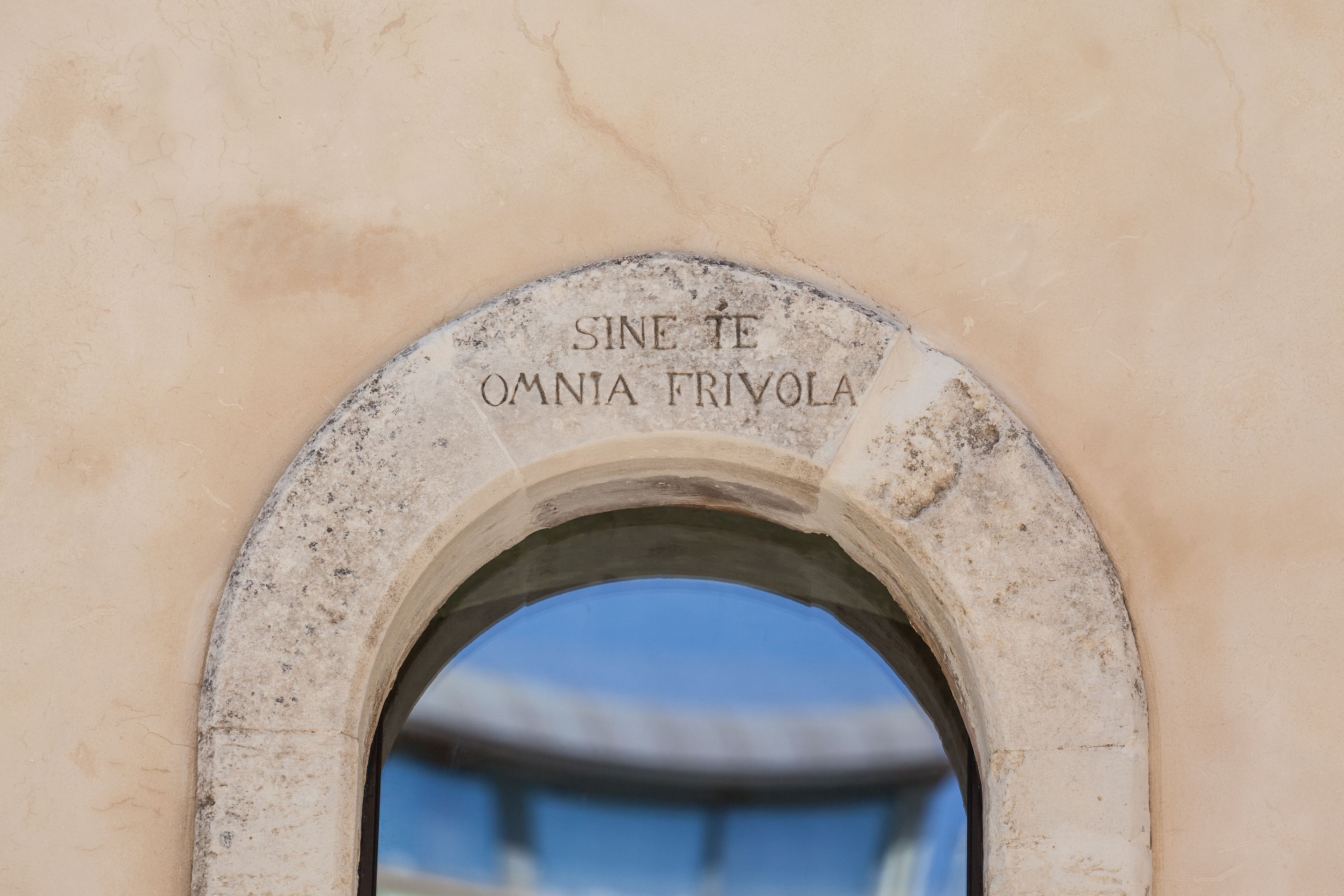 An arched doorway with the inscription "SINE TE OMNIA FRIVOLA."