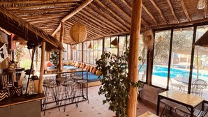 A spacious indoor area with a pool view, wooden ceiling, and seating arrangements. - Villa Florentine Marrakech (Marrakech)