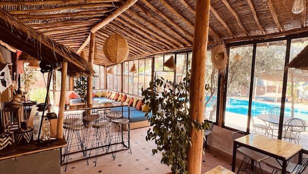 Amplio espacio interior con vista a la piscina, techo de madera y zonas de estar.