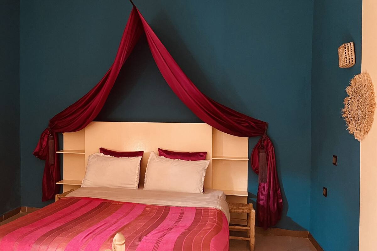 A bedroom with a bed, a canopy, and a nightstand.