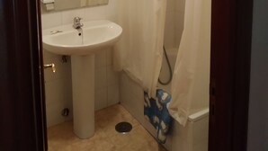 A bathroom with a sink, mirror, and shower curtain. - Hostal El Viejo Galeón (Baiona)