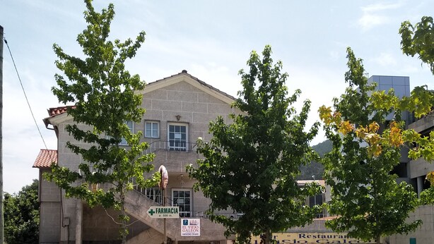 A building with a sign for 'FARMACIA' and 'El Viejo Gallego' restaurant. - Hostal El Viejo Galeón (Baiona)