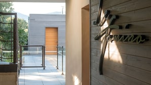 A modern building with a wooden facade and a metal sign. - Hotel le Tomino (Tomino)