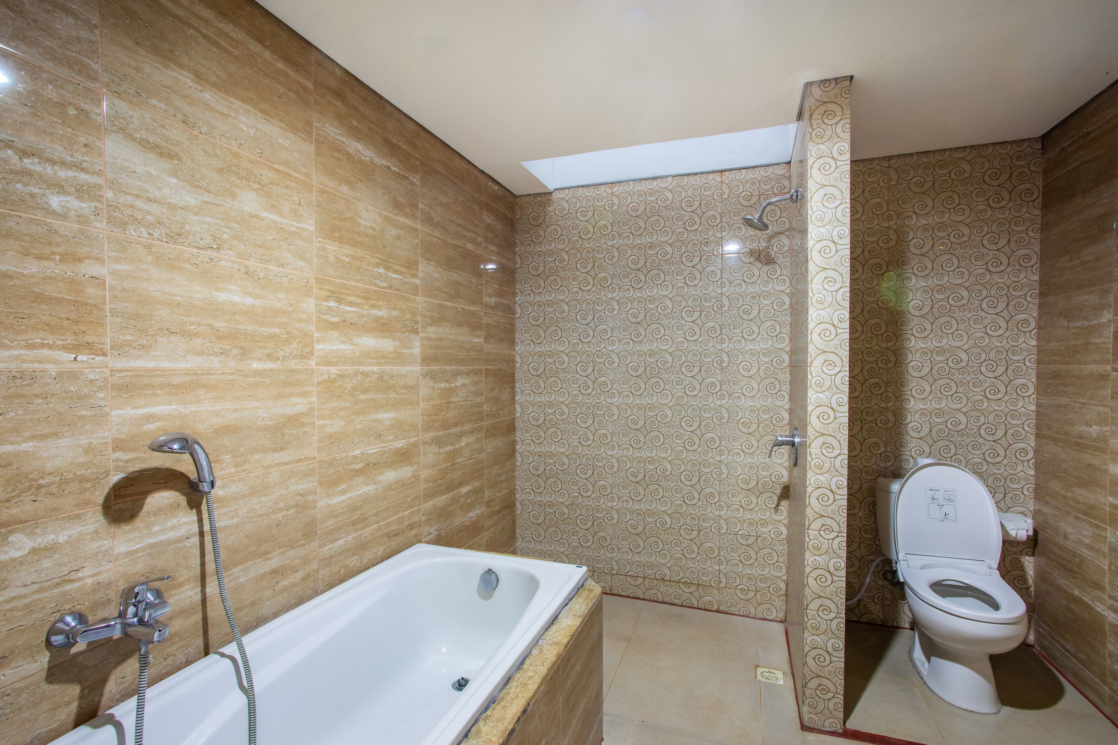 A bathroom with a bathtub, shower, and toilet.