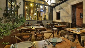 An indoor dining area with wooden tables and chairs, large windows, and hanging light fixtures. - Taxim Lounge Hotel - Special Class (Istanbul)