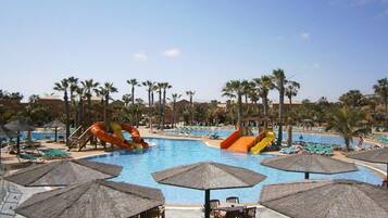 Een buitenzwembad, parasols bij het zwembad en ligstoelen