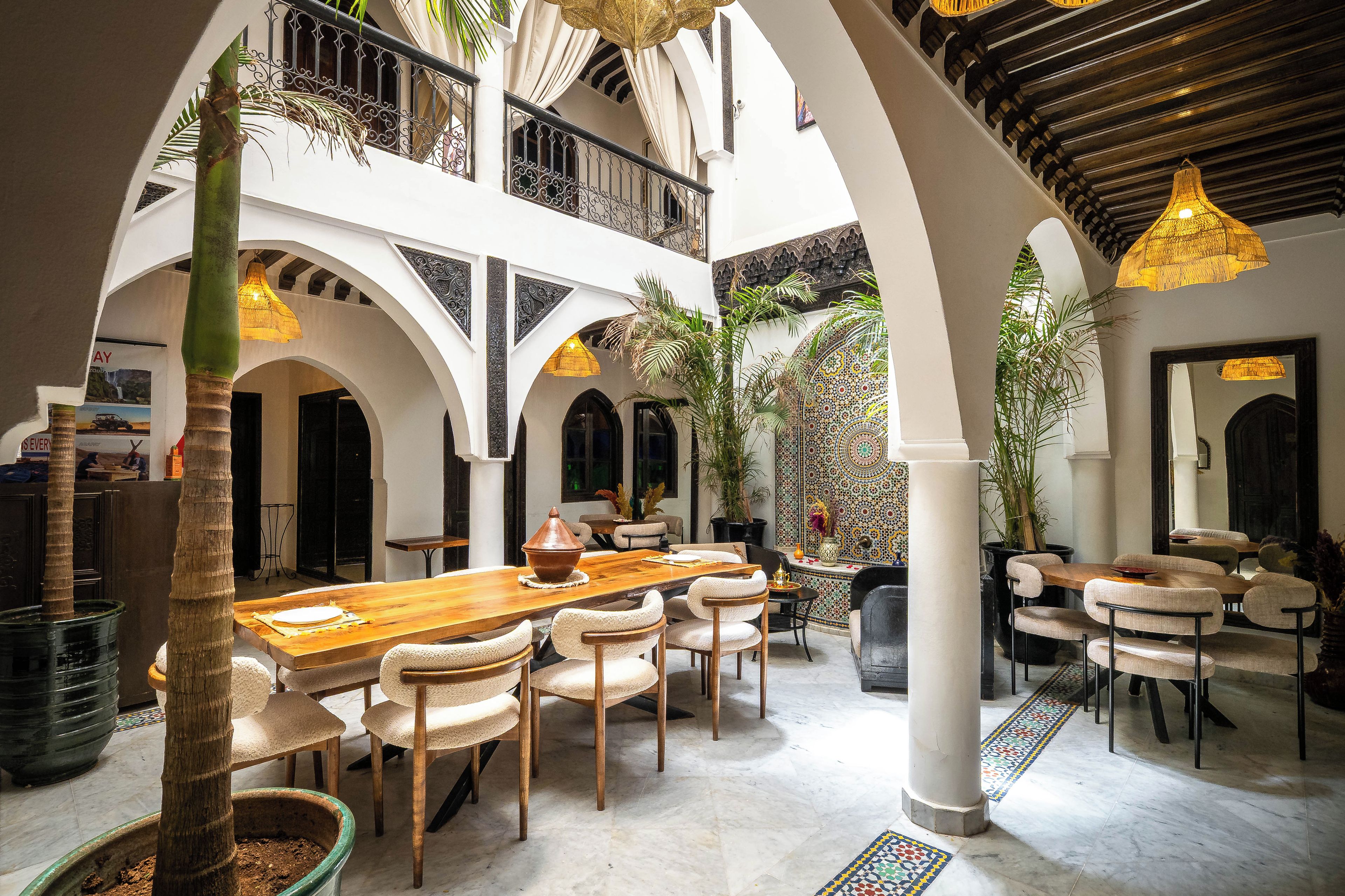 A spacious interior with a high ceiling, multiple dining areas, and a central courtyard with plants.