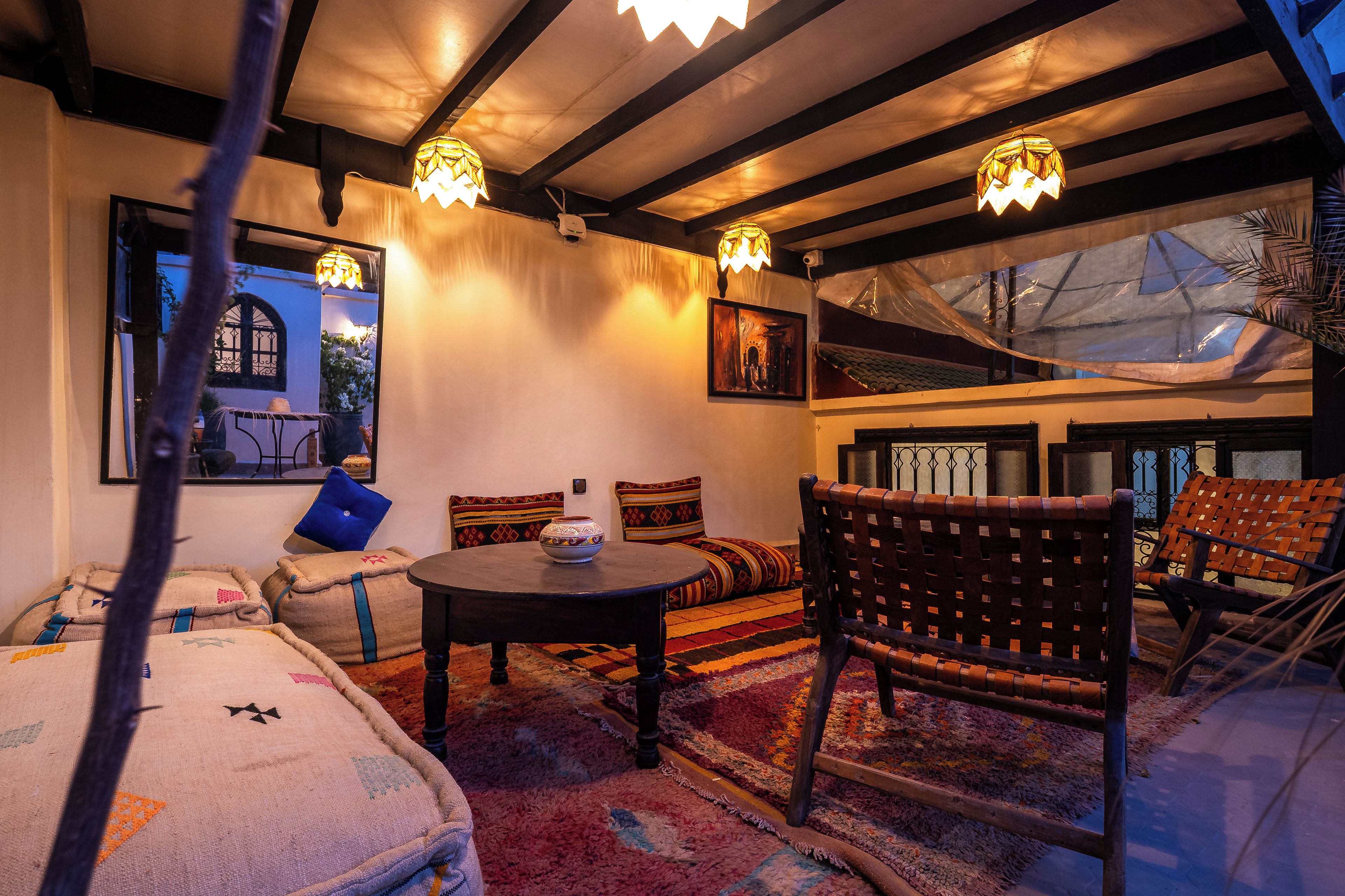 Un interior acogedor con una mesa redonda, asientos acolchados y un cuenco decorativo.
