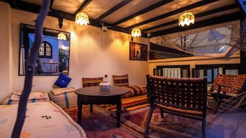 Un interior acogedor con una mesa redonda, asientos acolchados y un cuenco decorativo.