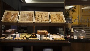 A buffet with various baked goods and pastries displayed in baskets.