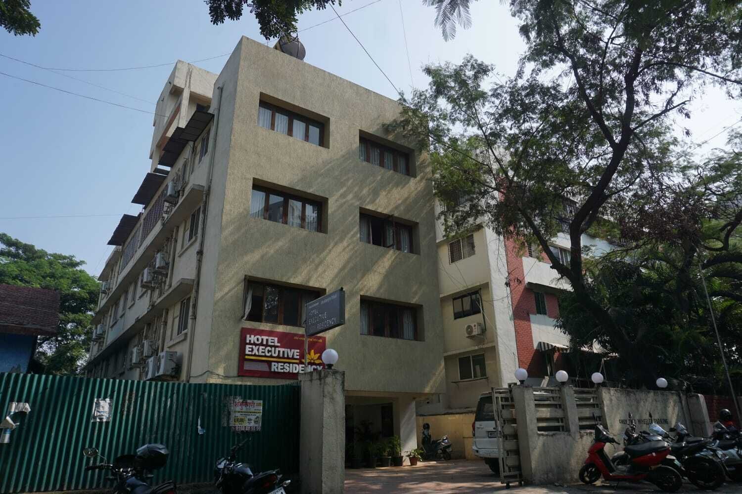 Un edificio de varios pisos con un cartel que indica que es una residencia ejecutiva hotelera.